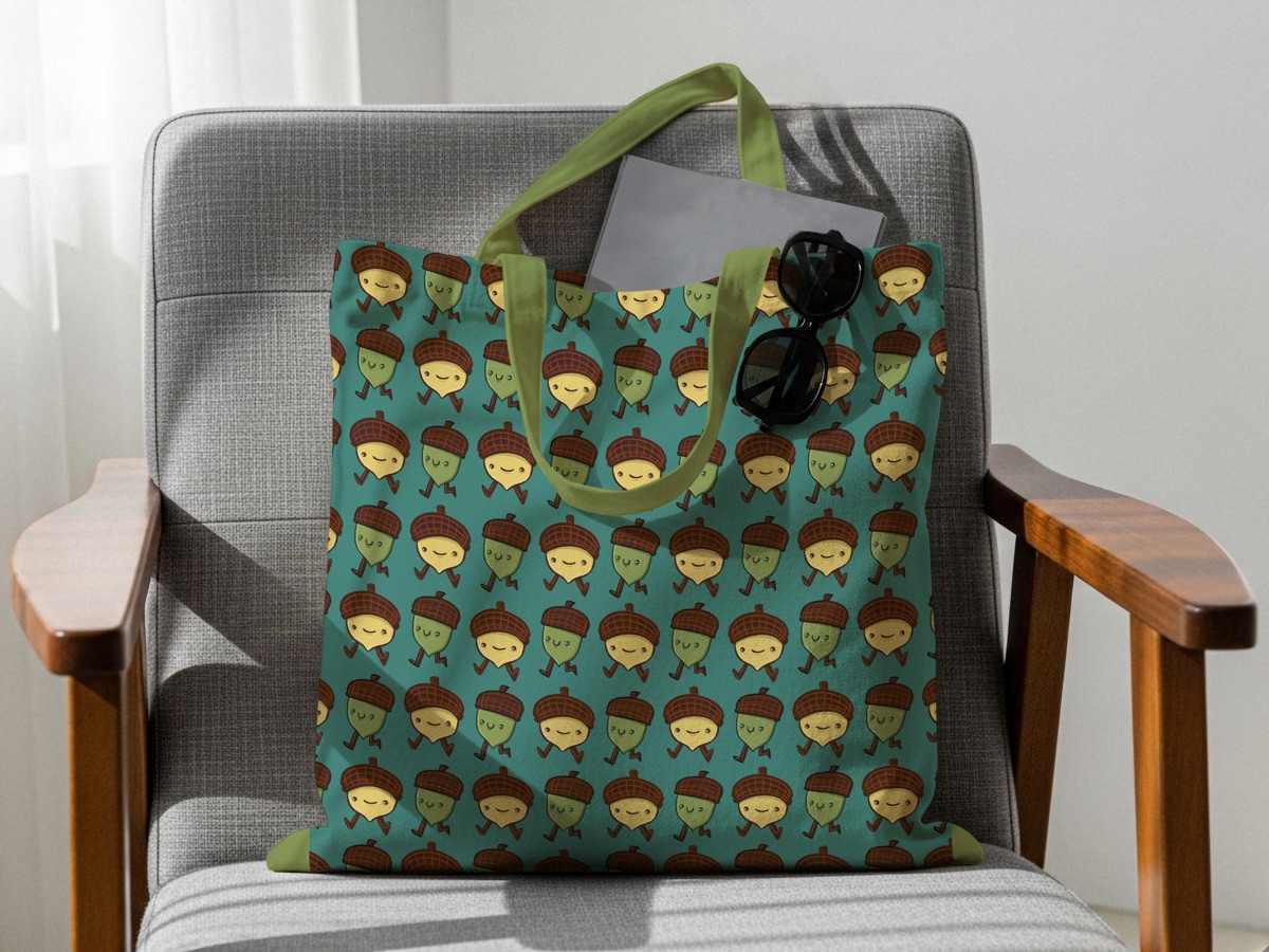 Tote bag printed with the walking acorn pattern on an armchair