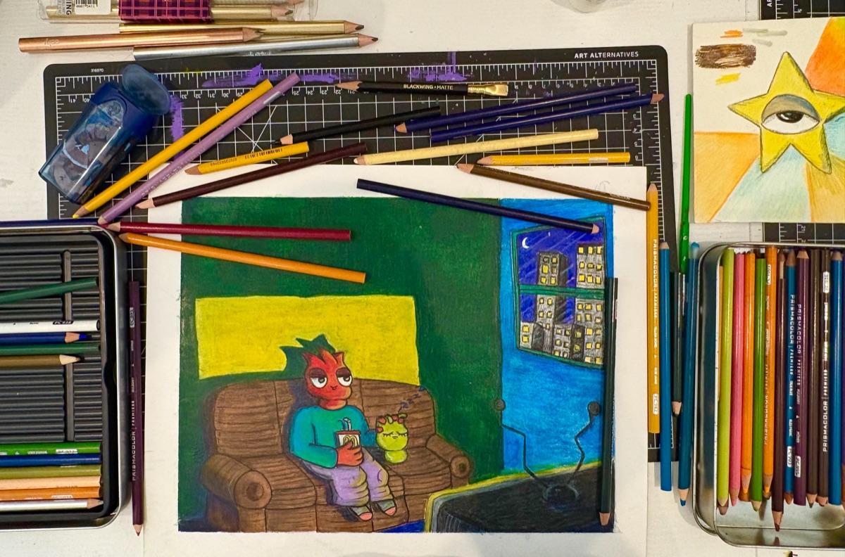 The drawing on a desk surrounded by colored pencils